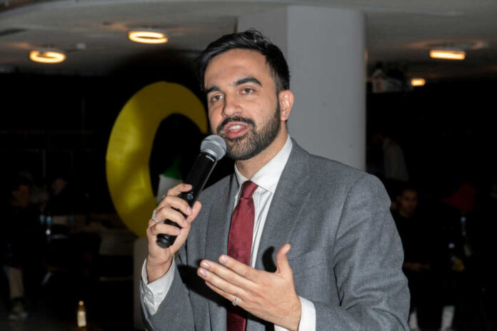 2595424777 A man in a suit speaking into a microphone at an event
